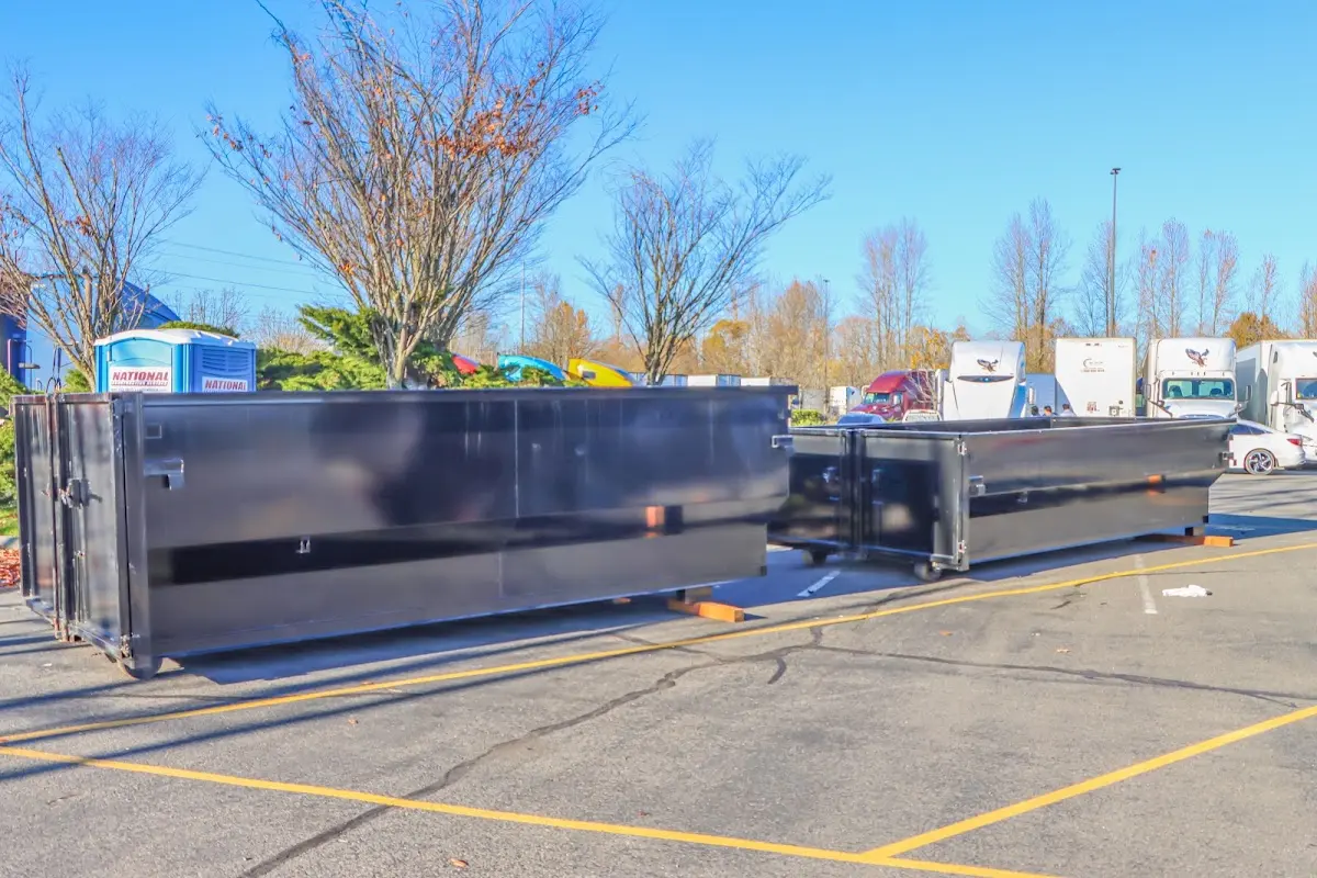 Professional dumpster rental service with roll-off container on residential driveway in Kingston